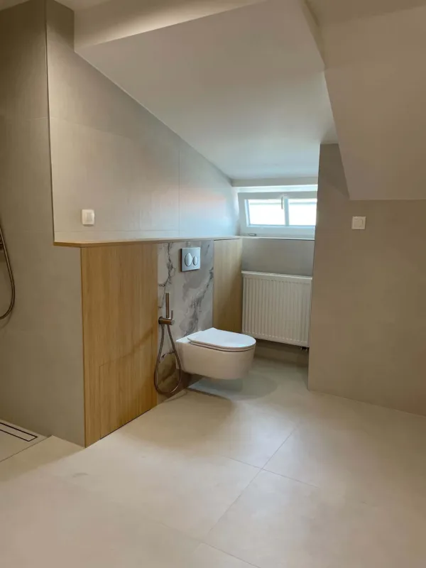 Podkrovná kúpeľňa s predstenou za WC obloženou drevom