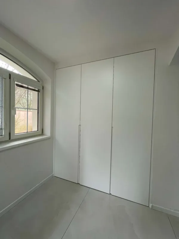 Biela bezúchytková vstavaná skriňa až po strop
