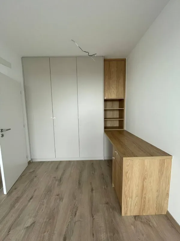 Detská izba so sivou vstavanou skriňou a písacím stolom v dekore dreva
