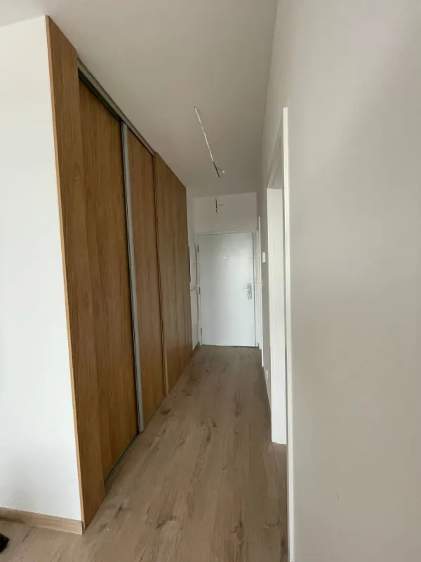 Vstavaná skriňa s posuvnými dverami v dekore dreva na chodbe