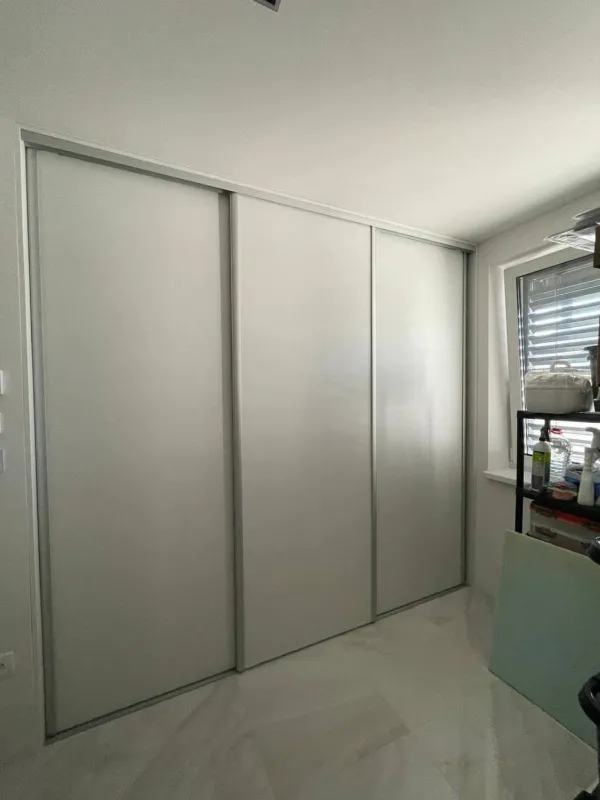 Vstavaná skriňa so svetlosivými posuvnými dverami v hliníkovom ráme