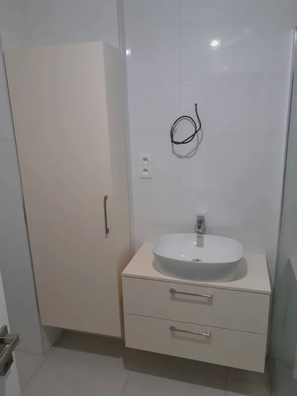 Biela kúpeľňová zostava so zásuvkami pod umývadlom a vysokou skrinkou