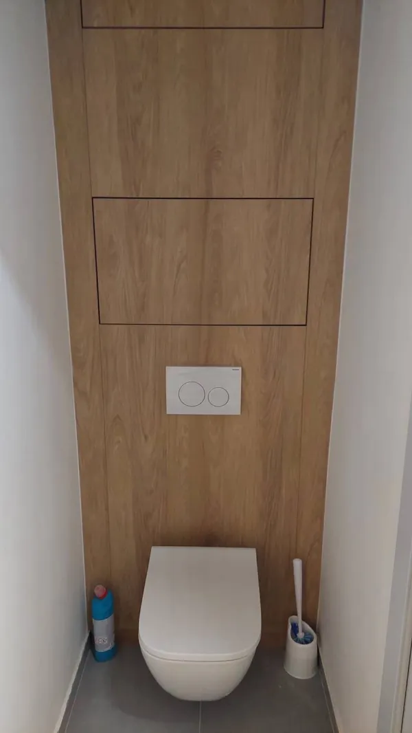 Obklad steny za WC v dekore dreva so skrytými revíznymi dvierkami